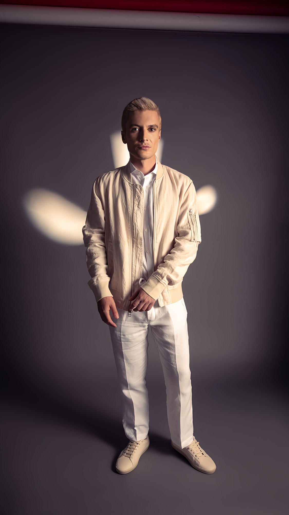 Founder · front halo. Primary portrait register — halo against the frame edge, figure at ~85% brightness, calm frontal gaze.